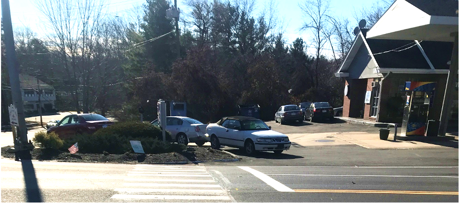 Figure 11 - View across Great Road (Route 117) of Southwest Intersection Corner. Image shows a crosswalk leading to a bed of mulch and vegetation at the perimeter of the gas station parking lot. Figure 11 - View across Great Road (Route 117) of Southwest Intersection Corner. Image shows a crosswalk leading to a bed of mulch and vegetation at the perimeter of the gas station parking lot.